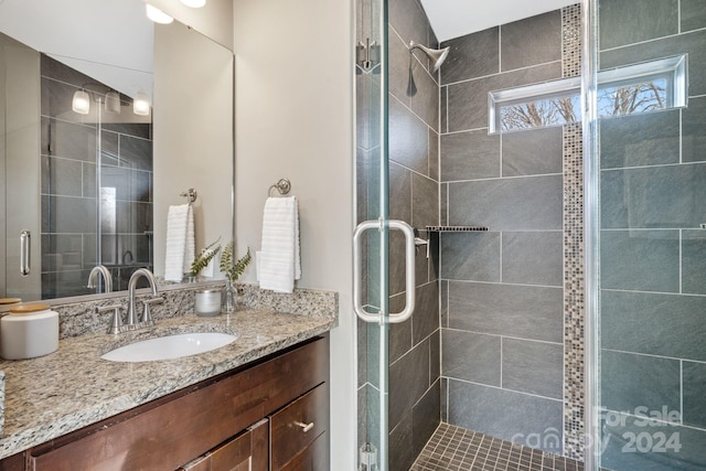 bathroom featuring vanity and a shower with door