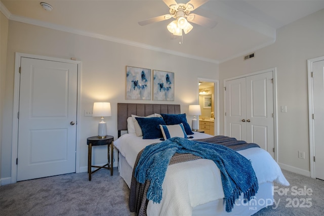 carpeted bedroom featuring crown molding, ensuite bath, ceiling fan, and a closet