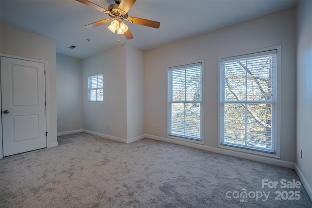 carpeted spare room with ceiling fan