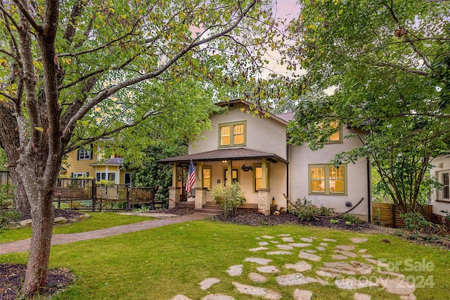 view of front of house with a porch and a front lawn