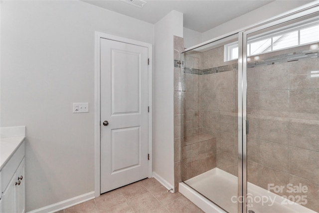 bathroom featuring a shower with shower door, vanity, and tile patterned floors