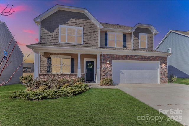 view of front of house featuring a garage, a yard, and a porch