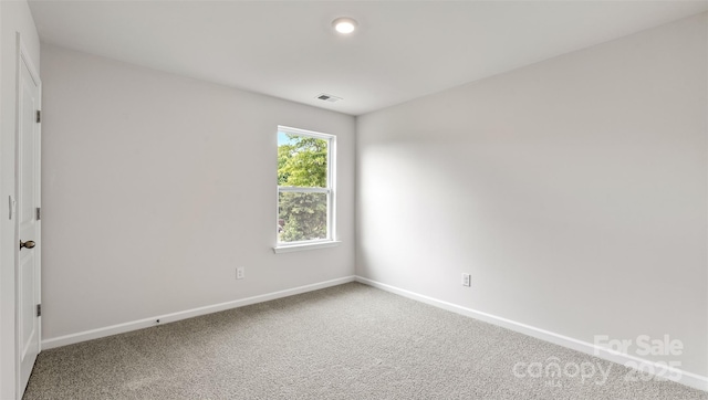 carpeted empty room with visible vents and baseboards