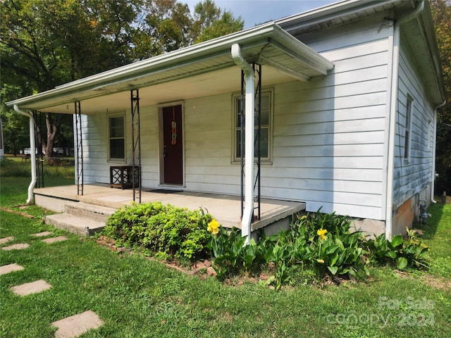 view of front of home with a front yard and covered porch