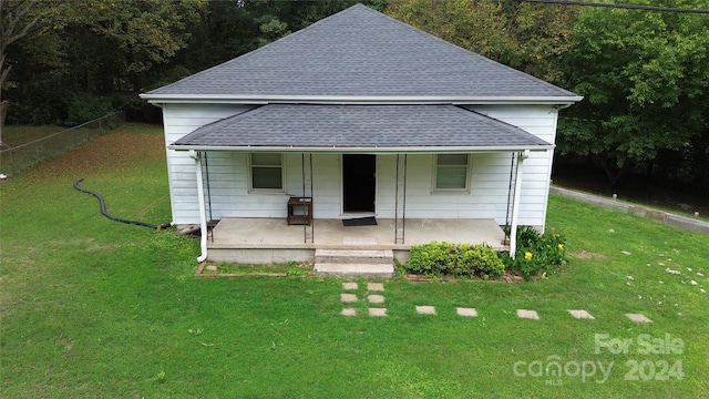 bungalow-style house featuring covered porch and a front yard