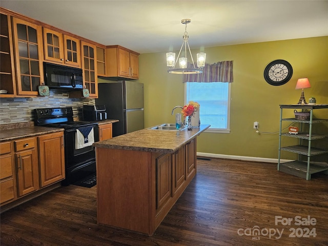 kitchen with a chandelier, sink, decorative backsplash, black appliances, and a center island with sink