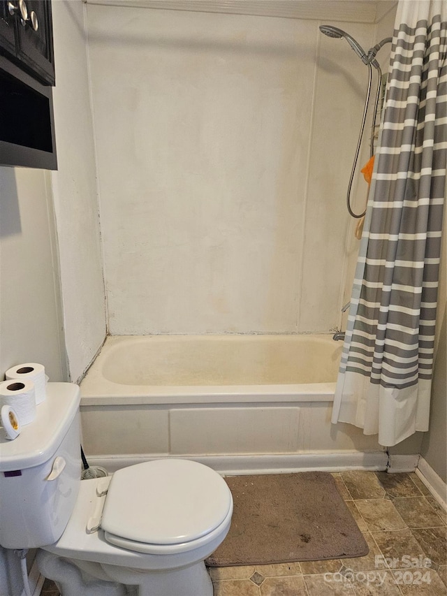 bathroom with toilet and shower / bath combination with curtain