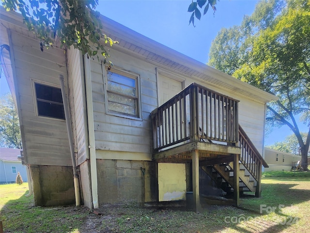 back of house with a wooden deck and a yard