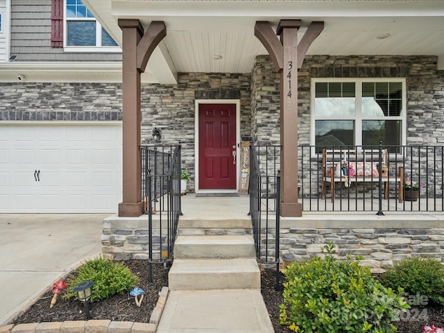 entrance to property with a garage and a porch