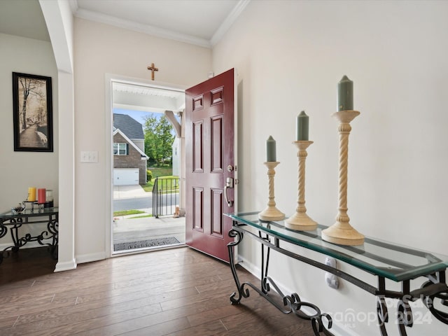 foyer with ornamental molding and dark hardwood / wood-style floors