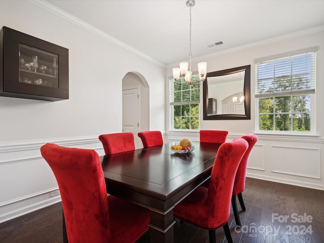 dining space with crown molding, an inviting chandelier, and dark wood-type flooring