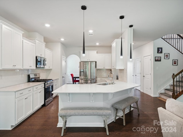 kitchen with pendant lighting, dark hardwood / wood-style floors, tasteful backsplash, sink, and appliances with stainless steel finishes