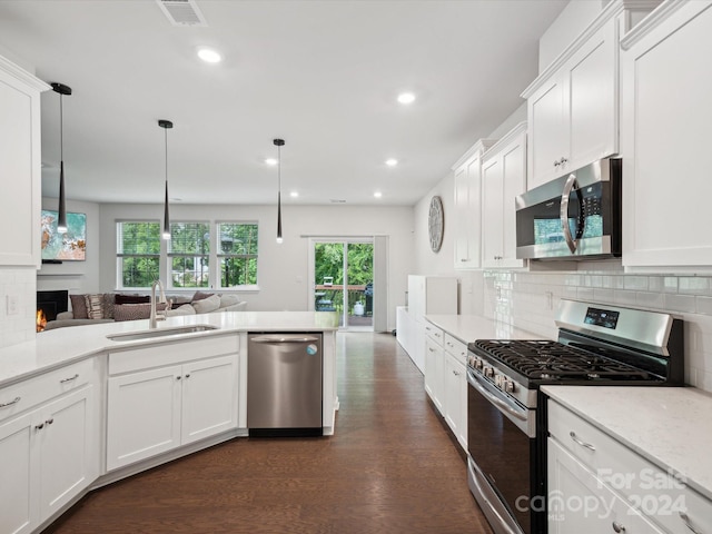 kitchen with white cabinets, decorative light fixtures, stainless steel appliances, dark hardwood / wood-style floors, and decorative backsplash