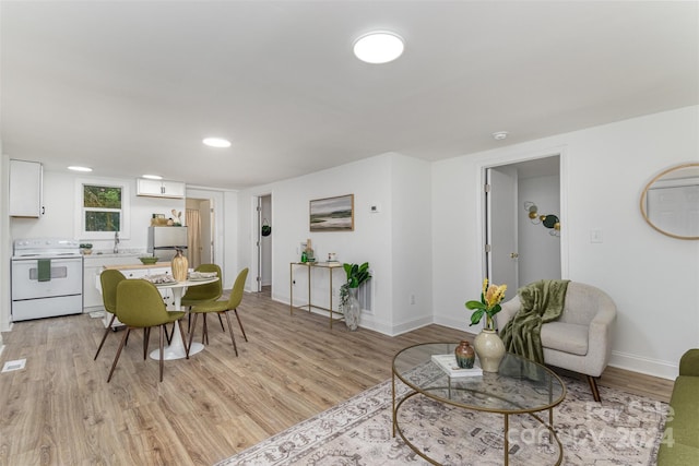 living room with sink and light hardwood / wood-style flooring