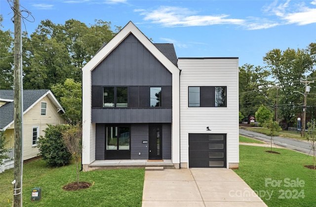 view of front of house featuring a garage, a front lawn, and a porch