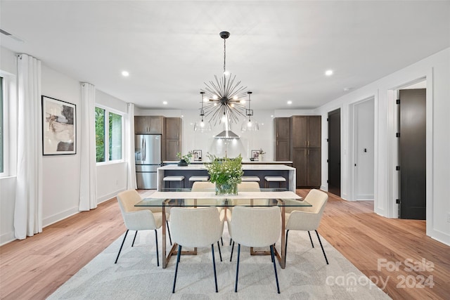 dining room featuring light hardwood / wood-style floors and a notable chandelier