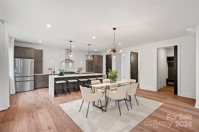 dining area featuring light hardwood / wood-style floors and an inviting chandelier