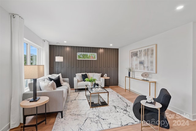 living room featuring light hardwood / wood-style flooring and wood walls