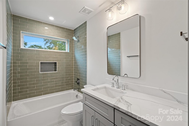 full bathroom with tiled shower / bath, toilet, and vanity