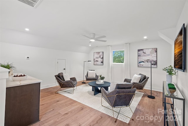 living room featuring ceiling fan, light hardwood / wood-style flooring, and lofted ceiling