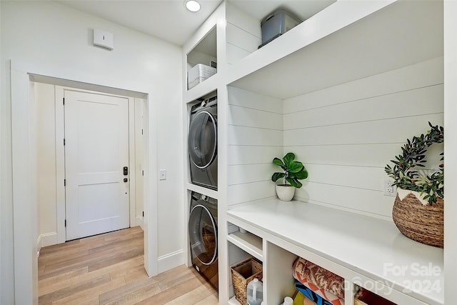 laundry area featuring light wood-type flooring and stacked washing maching and dryer