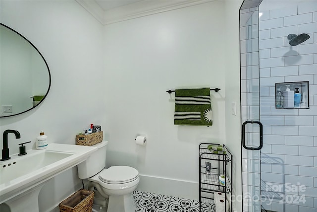 bathroom featuring ornamental molding, toilet, sink, and an enclosed shower