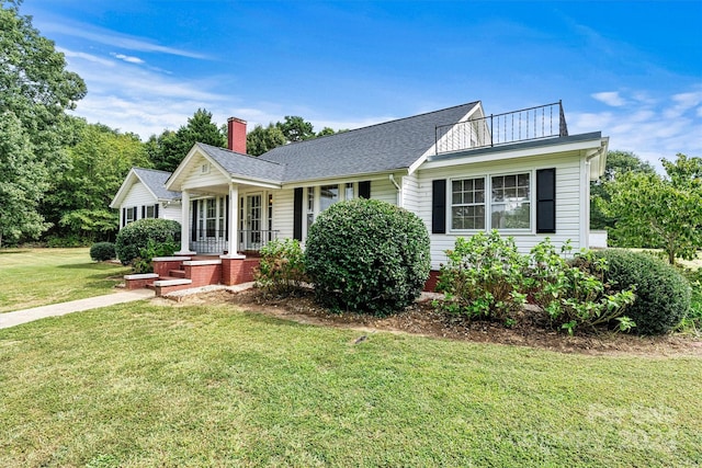 ranch-style home featuring a balcony, a front yard, and a porch