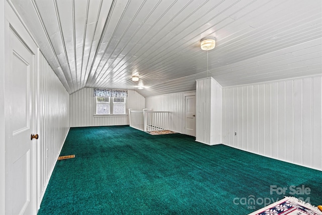 bonus room with wooden walls, vaulted ceiling, and carpet floors