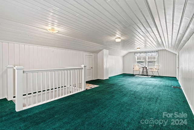 additional living space with lofted ceiling, wooden walls, wooden ceiling, and dark carpet