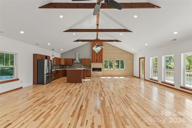 unfurnished living room featuring ceiling fan, light hardwood / wood-style flooring, beam ceiling, and high vaulted ceiling