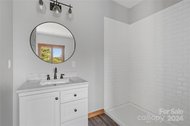 bathroom featuring vanity, hardwood / wood-style flooring, and tiled shower