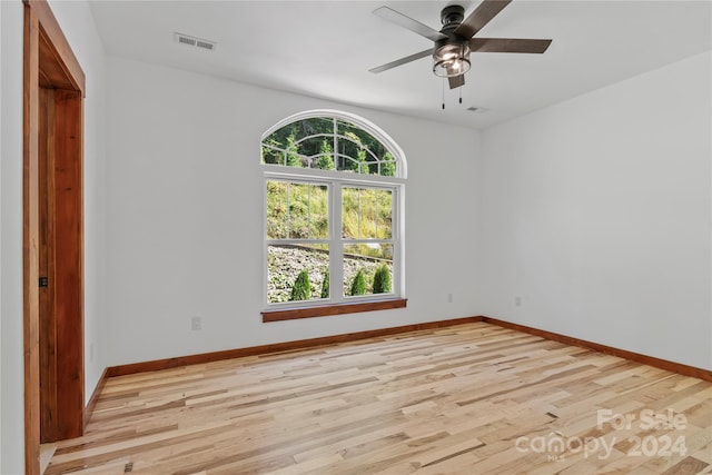 unfurnished room featuring a wealth of natural light, light hardwood / wood-style floors, and ceiling fan