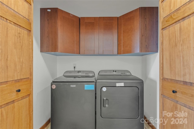 laundry area featuring cabinets and washing machine and clothes dryer