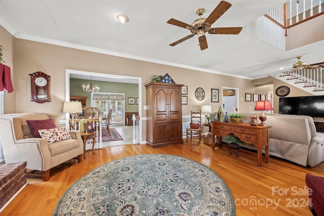 foyer entrance with ceiling fan with notable chandelier, crown molding, and light hardwood / wood-style flooring