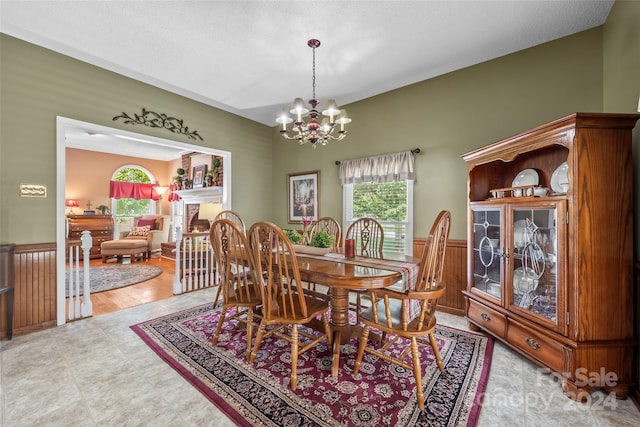 dining room featuring a notable chandelier, light hardwood / wood-style floors, and a textured ceiling