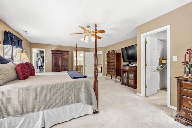 carpeted bedroom featuring ceiling fan, a closet, and a walk in closet