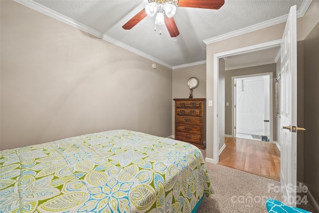 bedroom with ceiling fan, a textured ceiling, crown molding, and carpet flooring