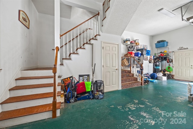 stairway featuring concrete flooring and a textured ceiling