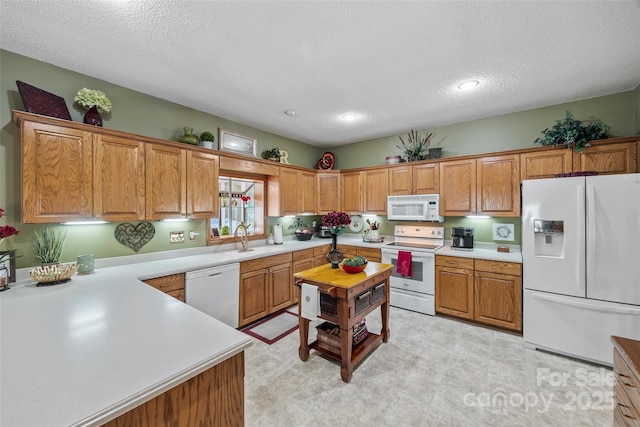 kitchen with sink, white appliances, and a textured ceiling