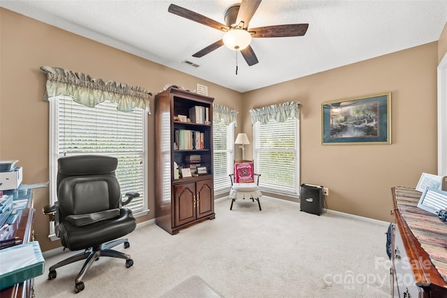 carpeted office featuring ceiling fan and a textured ceiling