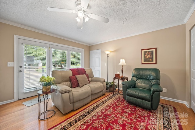 living room featuring crown molding, a textured ceiling, ceiling fan, and light wood-type flooring