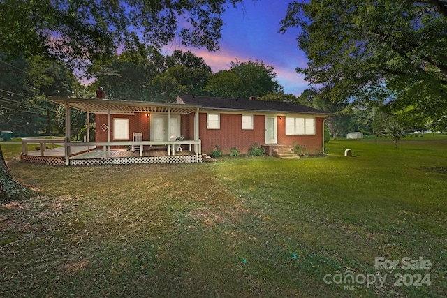 view of front of home featuring a pergola, a deck, and a lawn