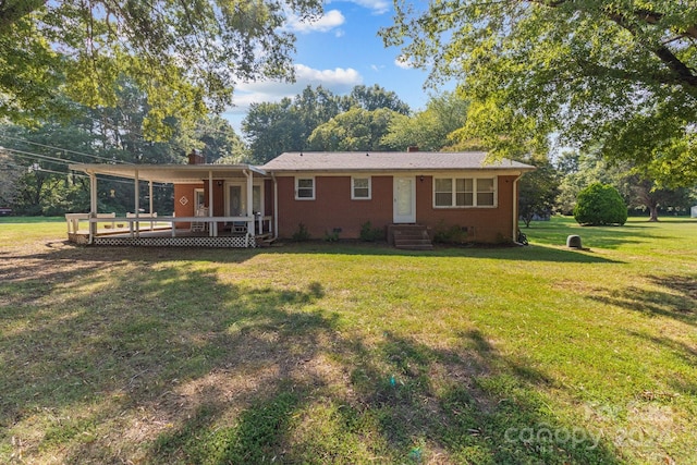 back of house featuring a wooden deck and a yard