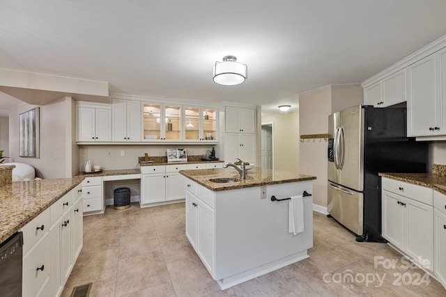 kitchen featuring white cabinetry, dishwasher, light stone countertops, a center island with sink, and sink