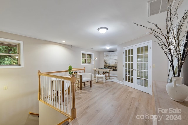 living area with light wood-type flooring and french doors