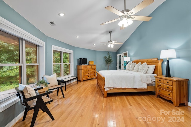 bedroom with light hardwood / wood-style flooring, ceiling fan, and high vaulted ceiling