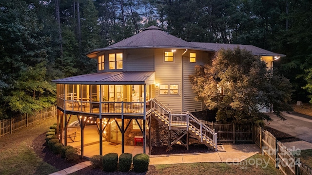 back of house featuring a deck and a patio area