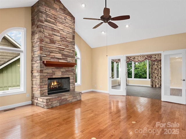 unfurnished living room featuring ceiling fan, high vaulted ceiling, a fireplace, and light hardwood / wood-style flooring