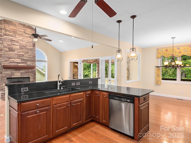 kitchen featuring a wealth of natural light, pendant lighting, sink, stainless steel dishwasher, and light wood-type flooring