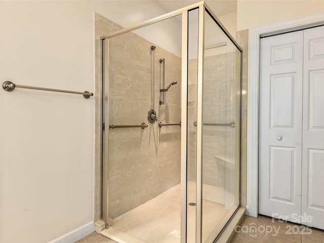 bathroom with a shower with door and tile patterned flooring